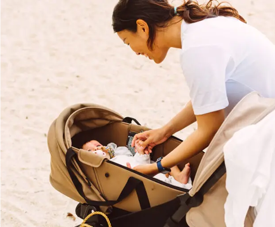 Picture → Nannimoon nanny attending to a baby in a stroller during a family vacation in Thailand