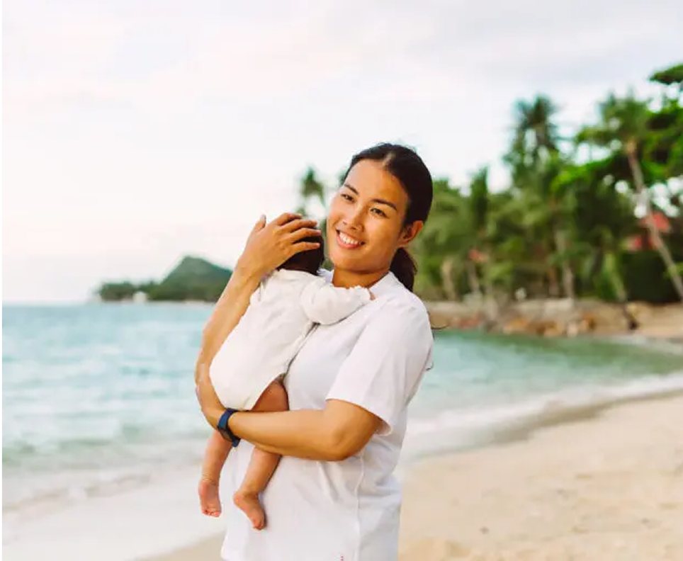 Picture → Nannimoon nanny providing professional childcare while holding a baby by the ocean
